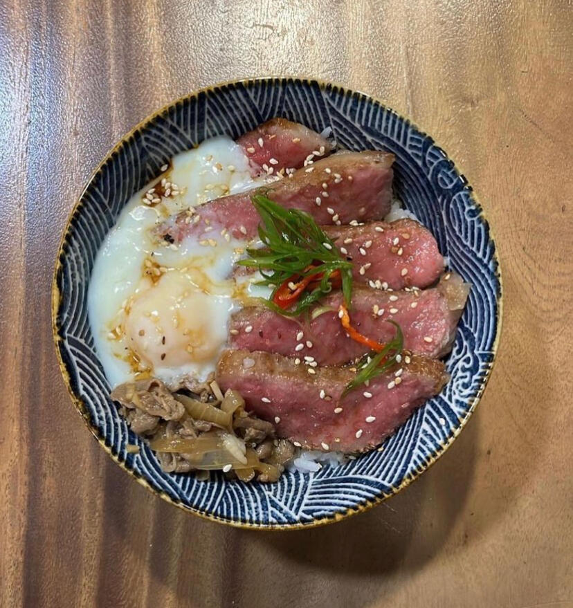 A5 Wagyu beef don topped with a soft boiled egg, garnished with garlic chips, spring onions and sesame seeds.